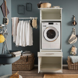 Laundreezy LDSK1W Milieu offen_91-210-17_70-200-17+37-202-17 Geöffnete Waschstele in einem Haushaltsraum mit sichtbarem Stauraum oberhalb und unterhalb des Geräts.