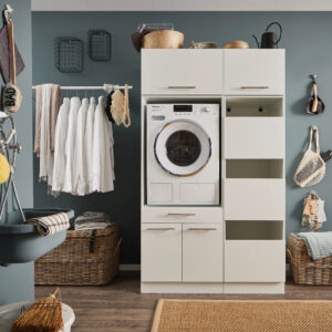 Ein Waschraum mit eingebauter Waschmaschine, offenen Regalfächern, einer Kleiderstange mit weißen Hemden, Körben und einem Wandwaschtrog.