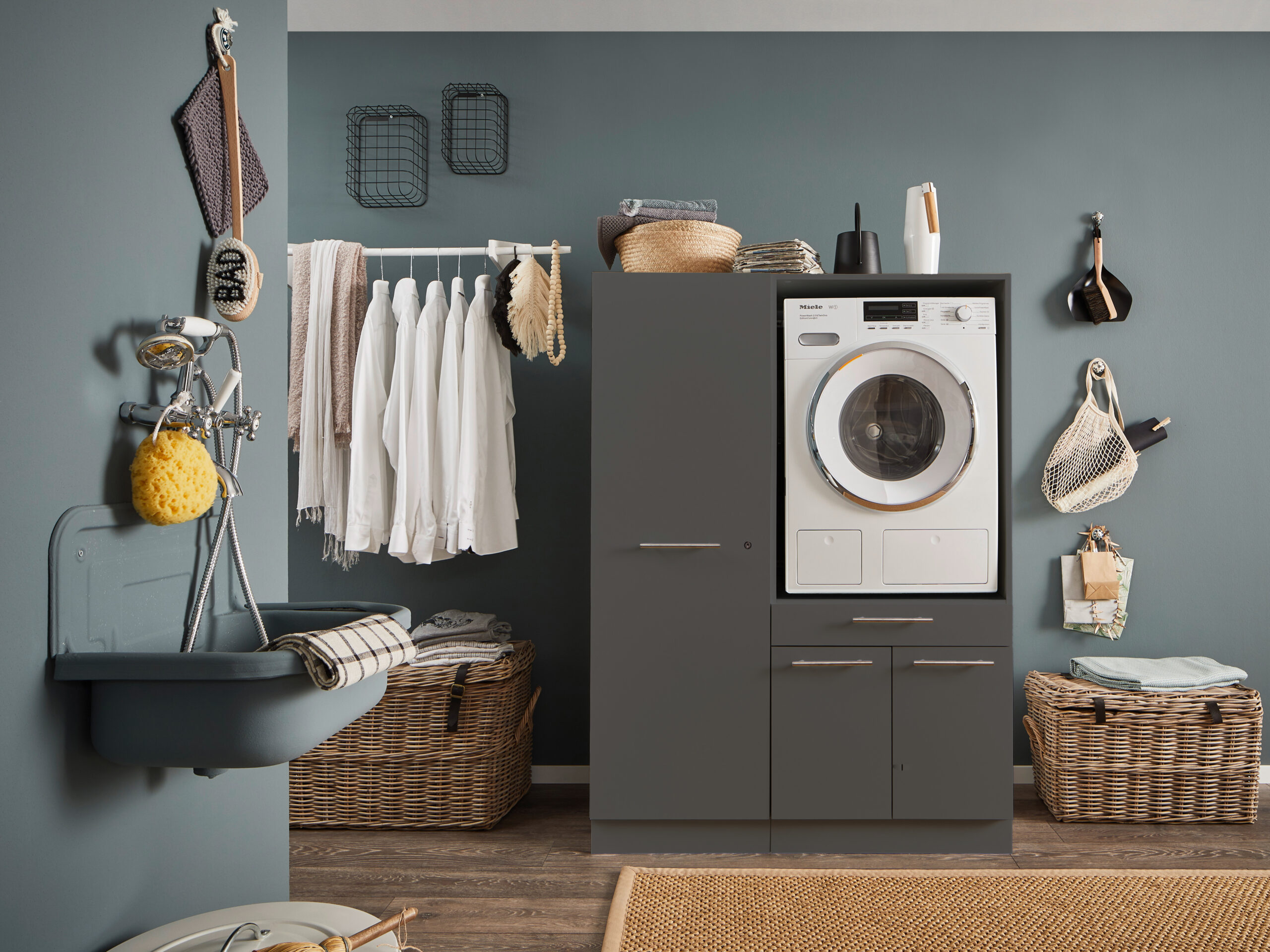 Geschlossener Waschmaschinen Schrank in Anthrazit mit integriertem Gerät in moderner Waschküche.