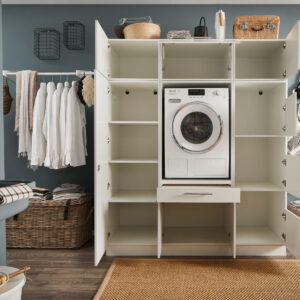 Weißes Schranksystem im Hauswirtschaftsraum mit integrierter Waschmaschine und vollständig geöffneten Türen.